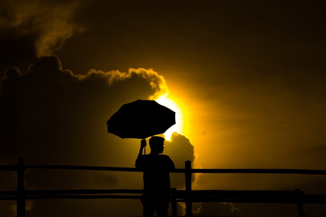 why-choose-us A man stood at the bridge with an umbrella to protect him from the sun.