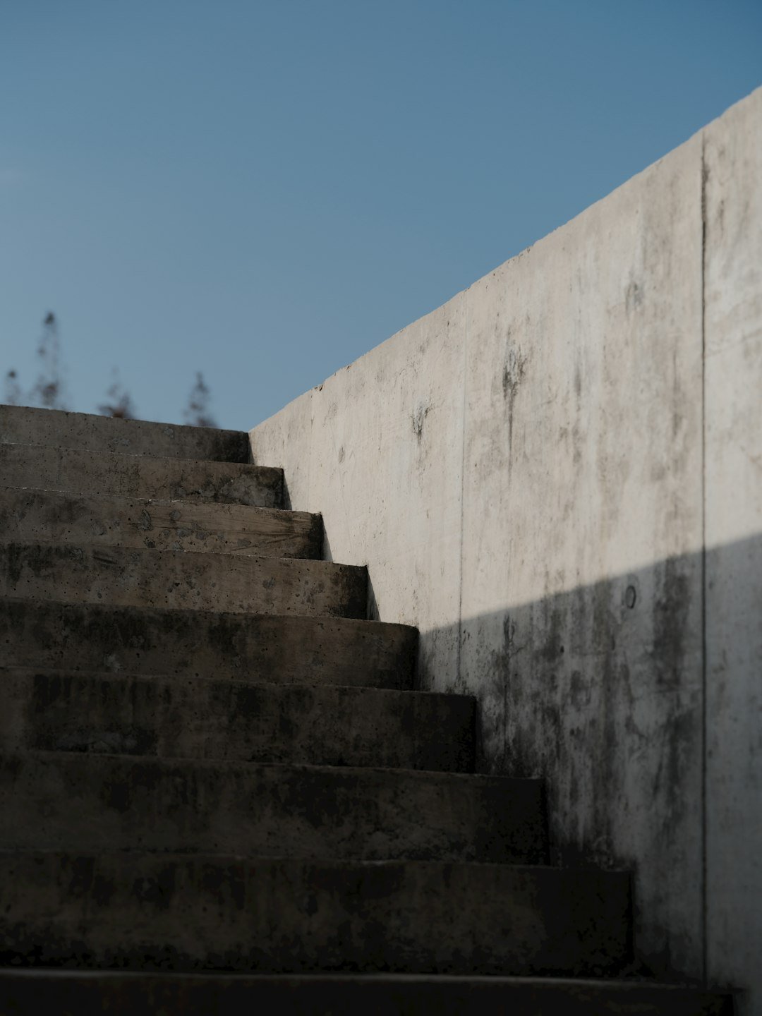 concrete-stairs-ascend-against-a-clear-blue-sky-zsw6xuyeopm