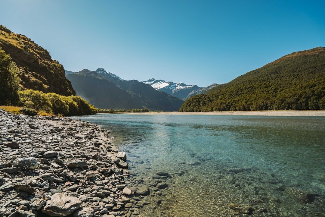 green-mountains-beside-body-of-water-during-daytime-i2bcftdjkjq